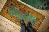 A person standing on the vintage Nichols rug demonstrates the runner's scale and vibrant color.