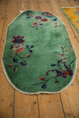 Elongated scalloped silhouette of a vintage Nichols Art Deco rug with a jade green field.