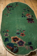 Low pile and visible foundation on an oval Nichols Art Deco rug with scattered floral sprays.