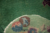 The worn jade green pile and hand-knotted back of a vintage Nichols Art Deco rug.
