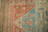 Distressed Malayer rug corner with Herati pattern detailed in ruby red, sky blue, and ivory.
