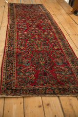 Vintage Sarouk runner displaying cherry red field, 'crown shyness' floral sprays, and deep navy border.