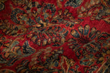 Vintage Sarouk rug's classic 'crown shyness' floral sprays in cherry red, navy, and jade green.