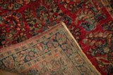 Cherry red floral pile of vintage Sarouk rug, with visible hand-knotted foundation.