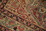 Kerman rug detail: ivory, cochineal red, sapphire vinery, with gentle wear showing foundation.