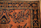 Transitional Sarouk rug detail: intricate dark navy, terra cotta floral border with abrash.