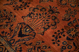 Transitional Sarouk rug: stylized sapphire blue floral bouquet on terra cotta field.