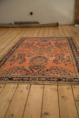 Transitional Sarouk rug corner, dusty rose field, navy floral motifs, and intact side selvage.