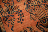 Vintage Sarouk rug detail: dusty rose field, speckled abrash, and navy floral motifs.