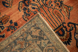 Folded vintage Sarouk rug corner, showing abrash, navy motifs, and detailed hand-knotted foundation.