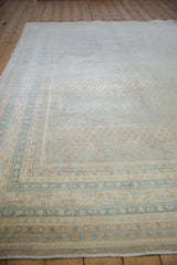Distressed sand and sky blue banded borders with allover boteh pattern on a vintage Mir Sarouk rug.