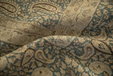 Distressed texture of vintage Meshed carpet, showing dusty blue and ivory boteh pattern.