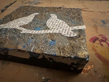 Textured mixed media art featuring silver leaf, blue paint, and black side panel.