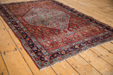 Angular sky blue medallion contrasting the pomegranate red Herati field of the vintage Bijar rug.