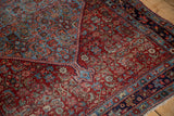 Vintage Bijar rug's contrasting curvilinear Herati motifs in pomegranate red and sky blue.