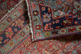 Vintage Bijar rug's corner reveals pomegranate red Herati field and multi-layered blue floral borders.