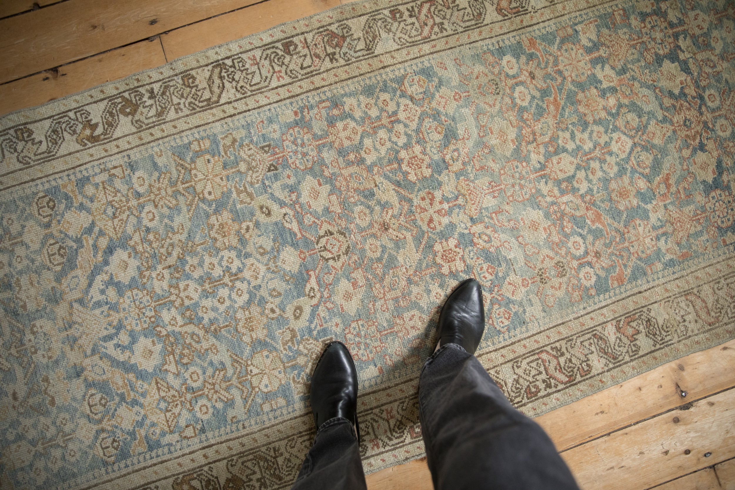 Distressed Hamadan runner with muted sky blue, beige, and madder red henna plant motifs.