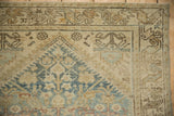 Distressed vintage Hamadan rug corner with henna plant motif, vine border, pale blue, ivory.