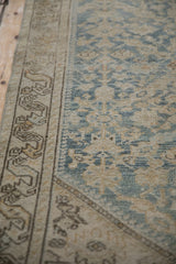 Worn texture of a vintage Hamadan runner, showing soft blue henna motif and vine border.