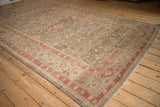 Persian Mahal rug corner: blush pinwheel florals, serrated leaves on an olive green field.