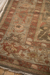 Fringed corner of antique Persian Mahal carpet: delicate plant and floral motifs, worn pile, blush, olive, terra cotta hues.