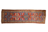 Collector antique Northwest Persian runner rug with brick red field, sapphire blue serrated medallion, and geometric blossoms.
