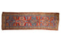 Collector antique Northwest Persian runner rug with brick red field, sapphire blue serrated medallion, and geometric blossoms.