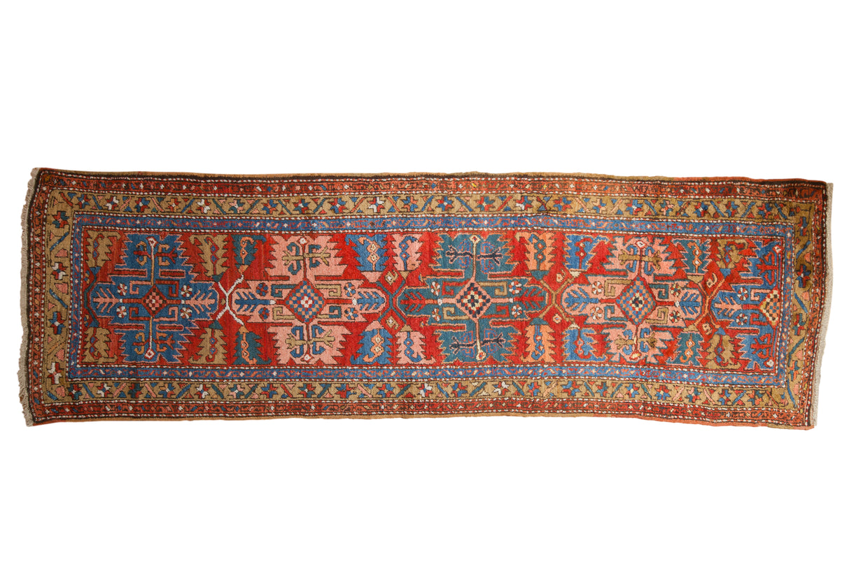 Collector antique Northwest Persian runner rug with brick red field, sapphire blue serrated medallion, and geometric blossoms.