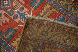 Antique Northwest Persian runner's reverse and pile, revealing hand-knotted foundation and red, blue, ochre patterns.