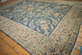 Distressed vintage Yezd carpet corner with ivory border, cobalt field, palmettes, and softened pile.