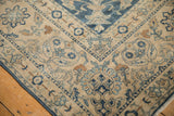 Distressed vintage Persian Yezd rug corner, showing cobalt blue and ivory floral vine motifs.