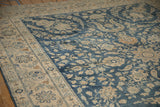 Distressed vintage Yezd rug corner with cobalt blue floral field, ivory border detail.