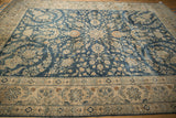 Faded cobalt blue field with floral blossoms and palmettes leading to an ivory border.