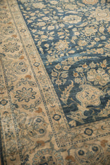 Distressed vintage Yezd carpet showing softened cobalt blue field and detailed ivory border patterns.