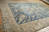 Distressed vintage Yezd rug's ivory border, featuring blue palmettes and pale coffee brown floral motifs.
