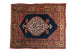 Antique Persian Bijar rug: ivory floral medallion, cobalt blue field, Herati spandrels, turtle samovar border.