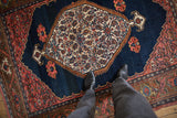 Antique Bijar rug's cobalt blue field, intricate paisley medallion, and blush serrated spandrels.