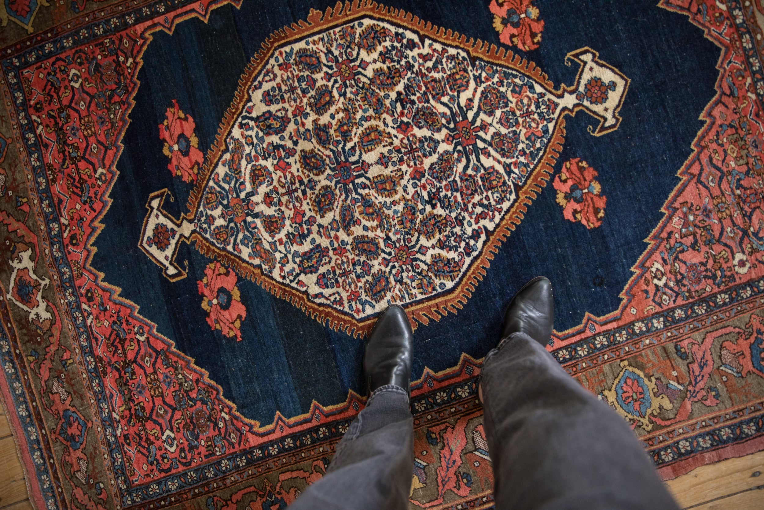 Antique Bijar rug's cobalt blue field, intricate paisley medallion, and blush serrated spandrels.