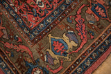 Antique Bijar rug corner showing rich ruby red, cobalt blue, and gold stylized patterns.