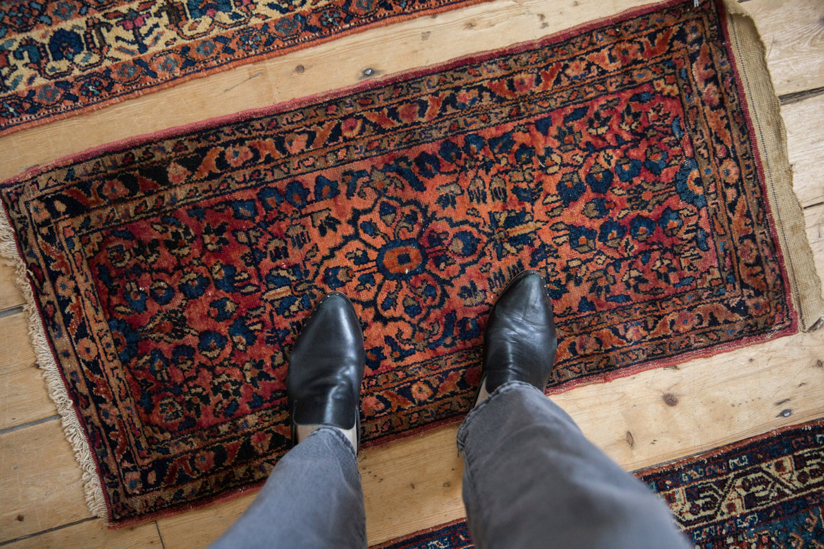 Antique Lilihan rug's shadow relief diamond medallion and sprawling blossoms in brick red, sapphire blue.