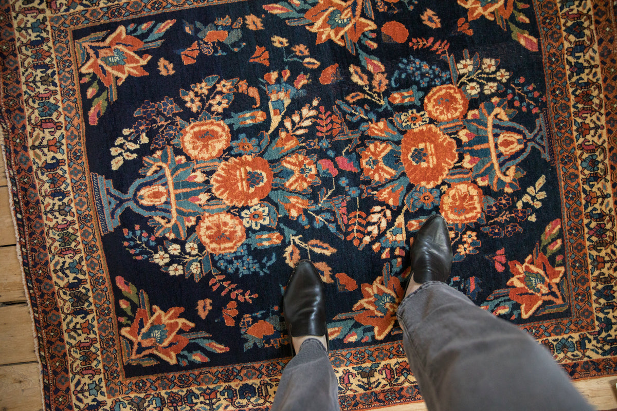 Antique Afshar rug with cobalt blue field, terracotta starburst florals, and ivory boteh border.