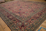 Antique Kerman border detail: cochineal red palmettes, dusty jade green vines, navy floral bells.