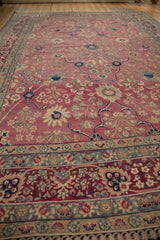 Antique Kerman carpet showing blush field with floral sprays, and palmette vine main border.