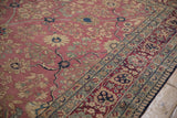 Antique Kerman carpet showcasing cochineal red palmette border and blush floral field.