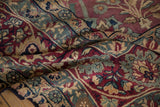 Rich floral palmettes and meandering vines on an antique Kerman carpet in blush, navy, and jade.