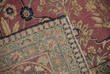 Antique Persian Kerman rug corner, cochineal red floral field, beige palmette border, and fringe.
