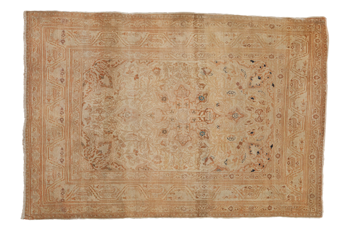 Antique Persian Tabriz rug with central pomegranate medallion and soft ivory-rust floral patterns.