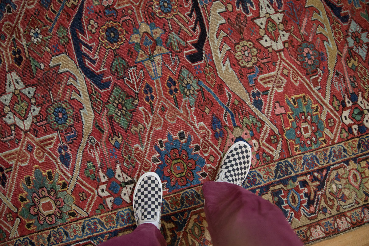 Antique Heriz carpet's geometric lattice with serrated leaves, in cherry red, cobalt, and emerald.