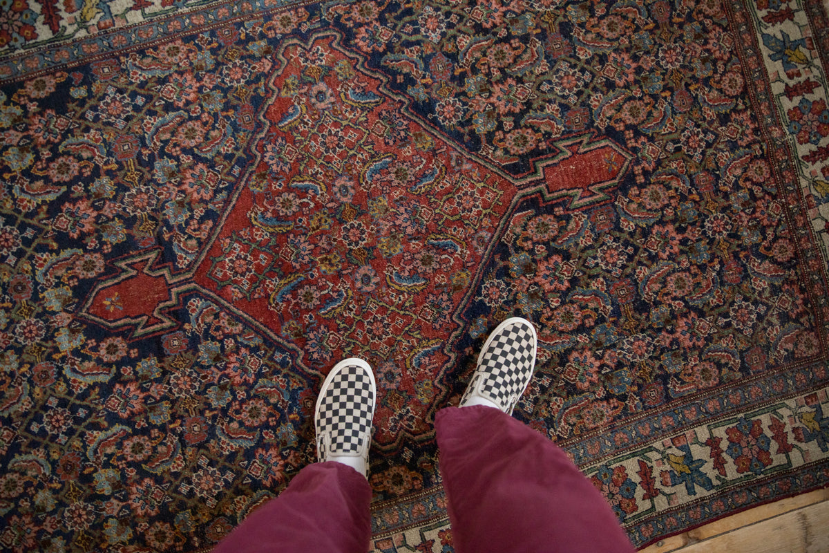 Antique Bijar rug's central brick red diamond medallion and Herati floral patterns.