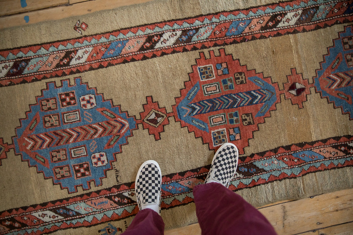 Geometric stepped diamond medallion and chevron border detail on antique Serab runner in blue, red, beige.